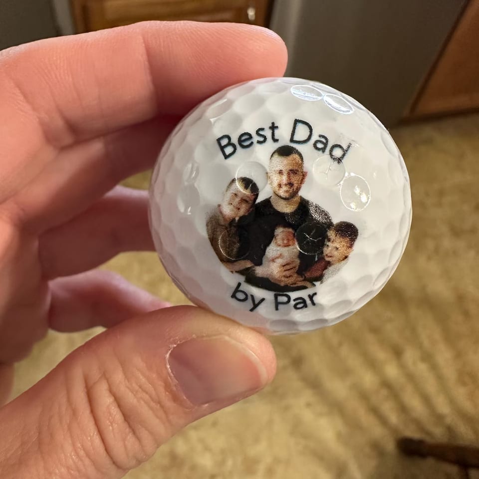 Best Dad by Par golf ball with a family photo, held in hand
